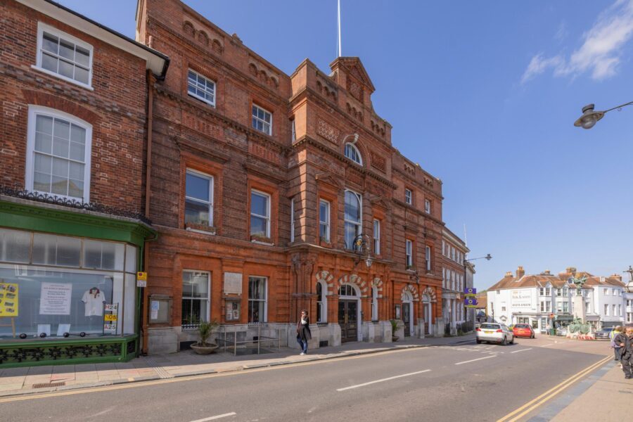Lewes Town Hall on the High Street, a red brick Victorian building with arched entrances.